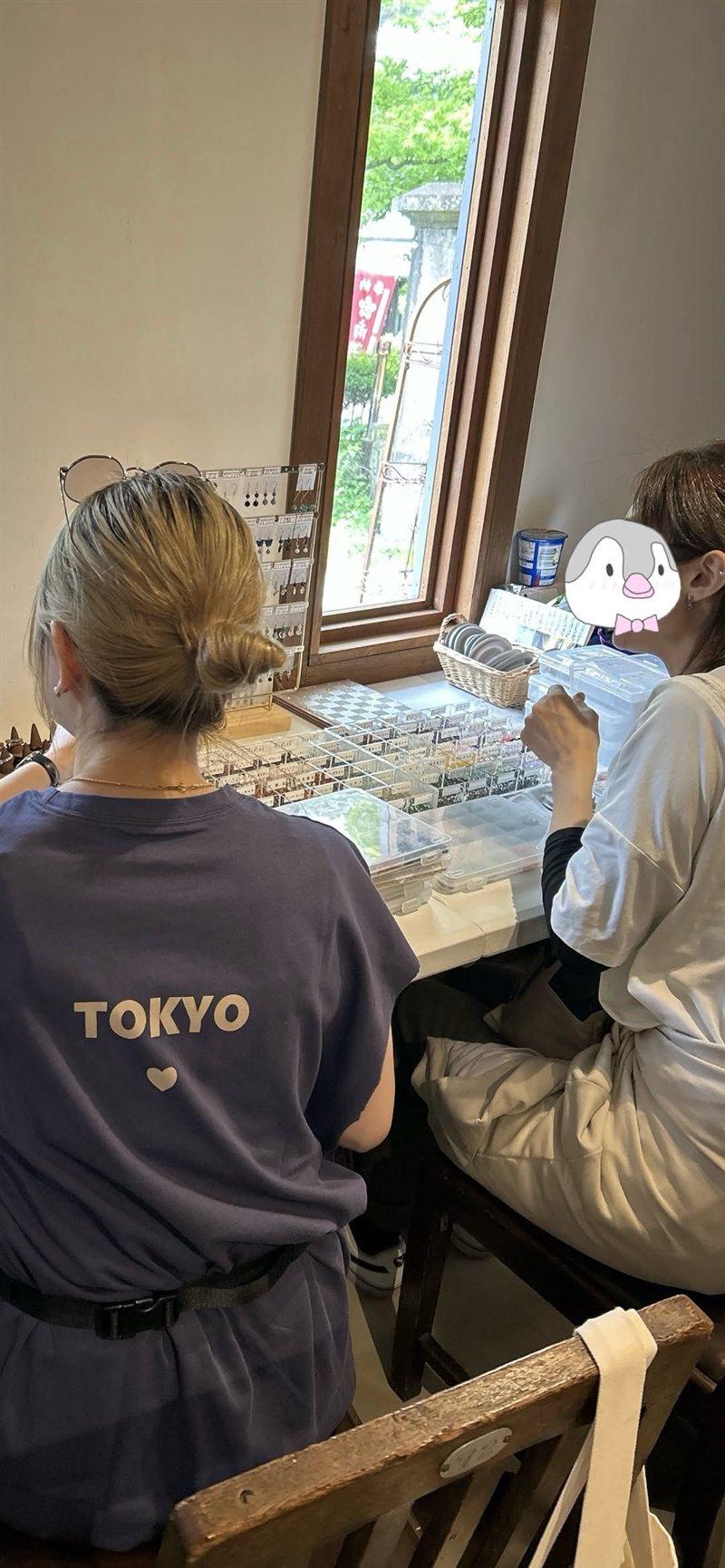 窓辺の席でブレスレット作りを楽しむ様子